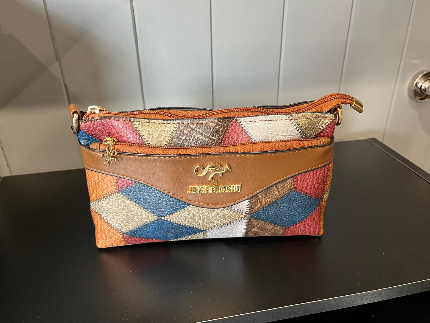 patterned handbag with a tan leather trim