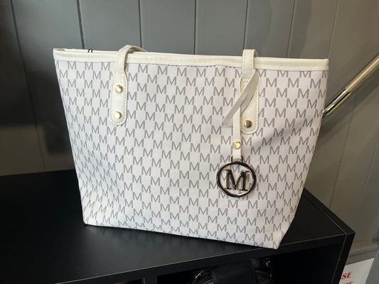 White tote bag with repeating monogram pattern and circular M logo